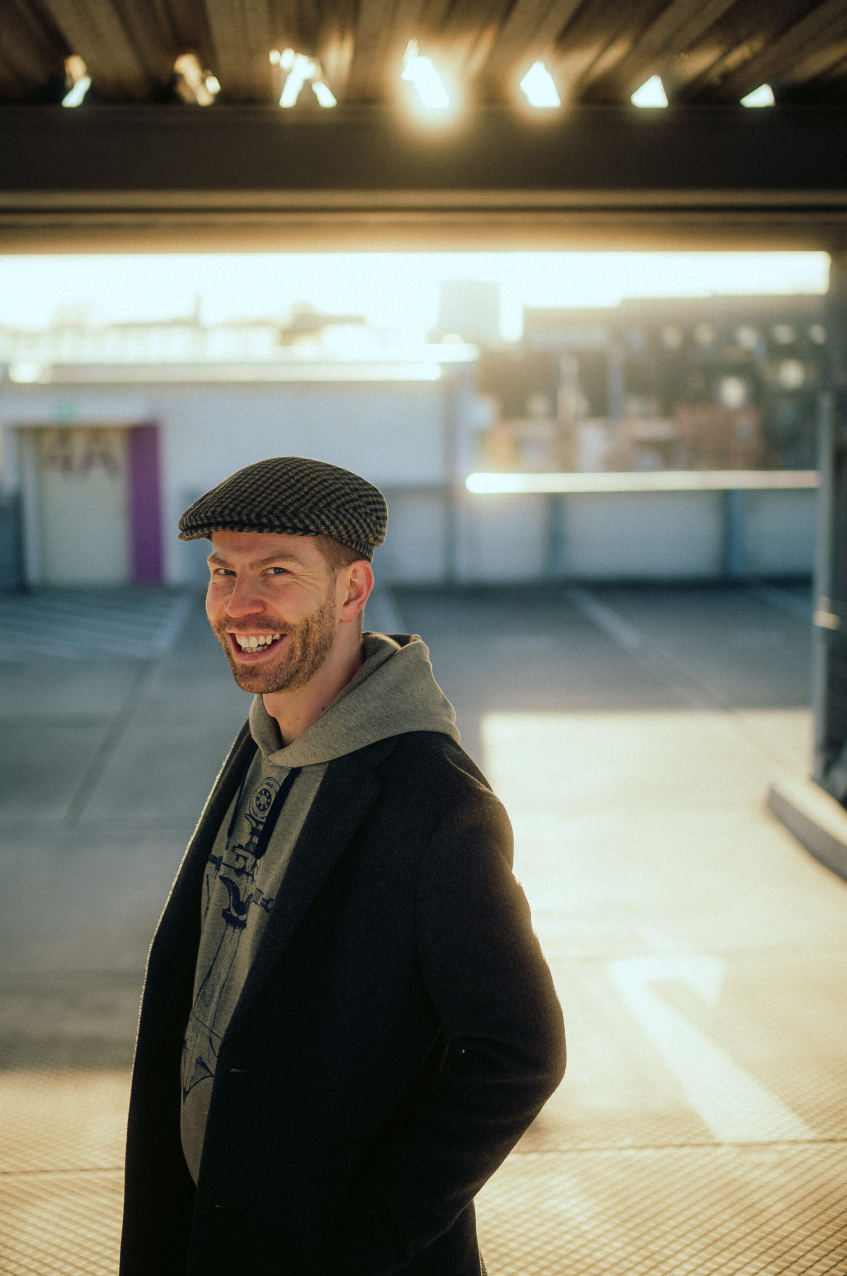Toni Borgert steht seitlich zur Kamera und lächelt genau in die Kamera. Im Hintergrund geht langsam die Sonne unter. Das Bild wurde von Fotograf Fritz Fechner geschossen.