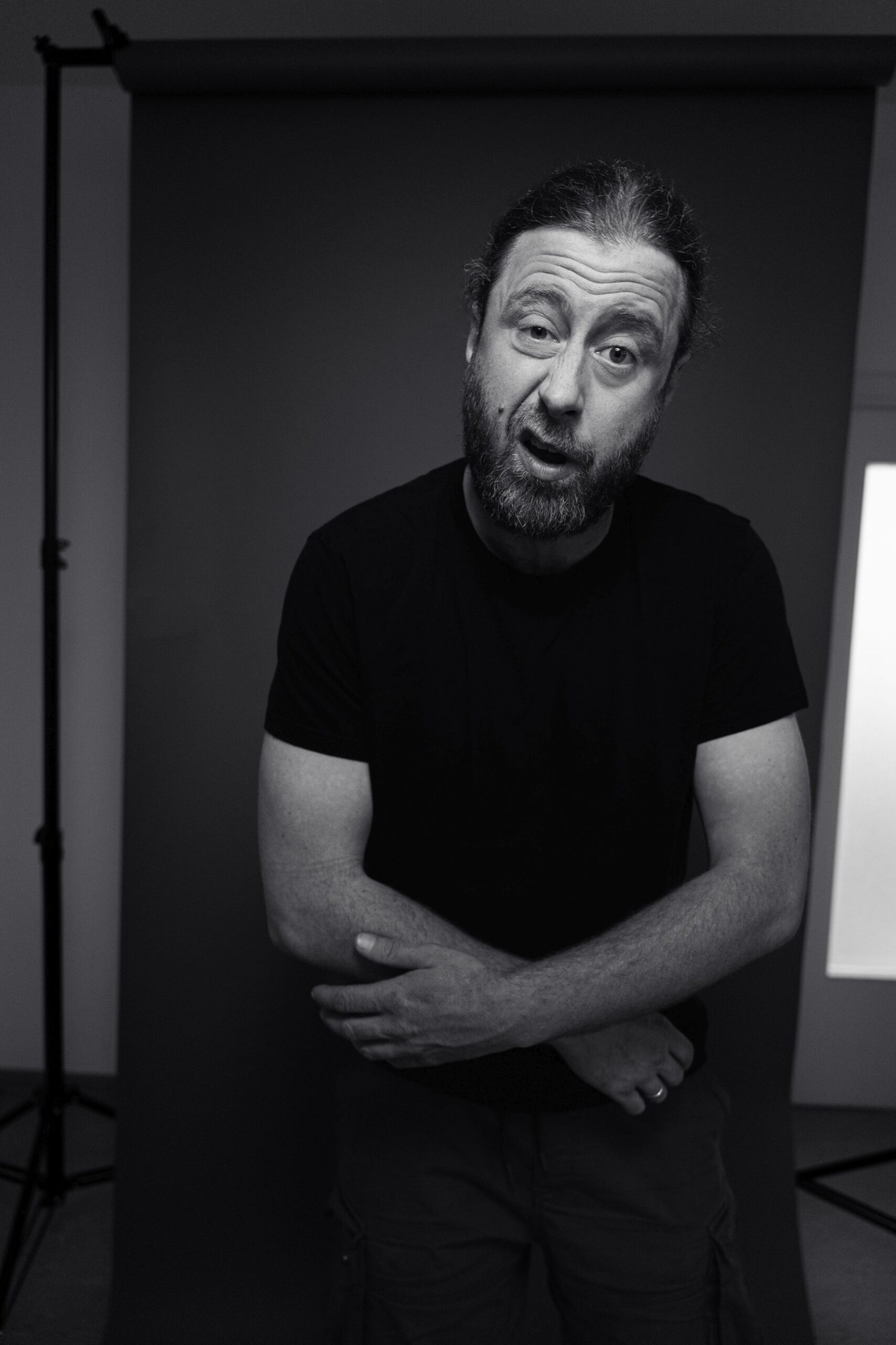 Das Foto zeigt den Rapper Keeko aus dem Ruhrgebiet in NRW. Auf dem Foto ist zu erkennen, dass beim Rappen fotografiert wurde. Er hat beide Arme vor seinem Körper gekreuzt und der Mund ist durch den Gesang geöffnet. Keeko hat die Augenbrauen angehoben und sein Gesichtsausdruck ist ernst. Im Hintergrund kann man sowohl den Raum als auch den Papierhintergrund erkennen, vor dem der Rapper fotografiert wurde. Das Foto wurde von Fotograf Toni Borgert aufgenommen.